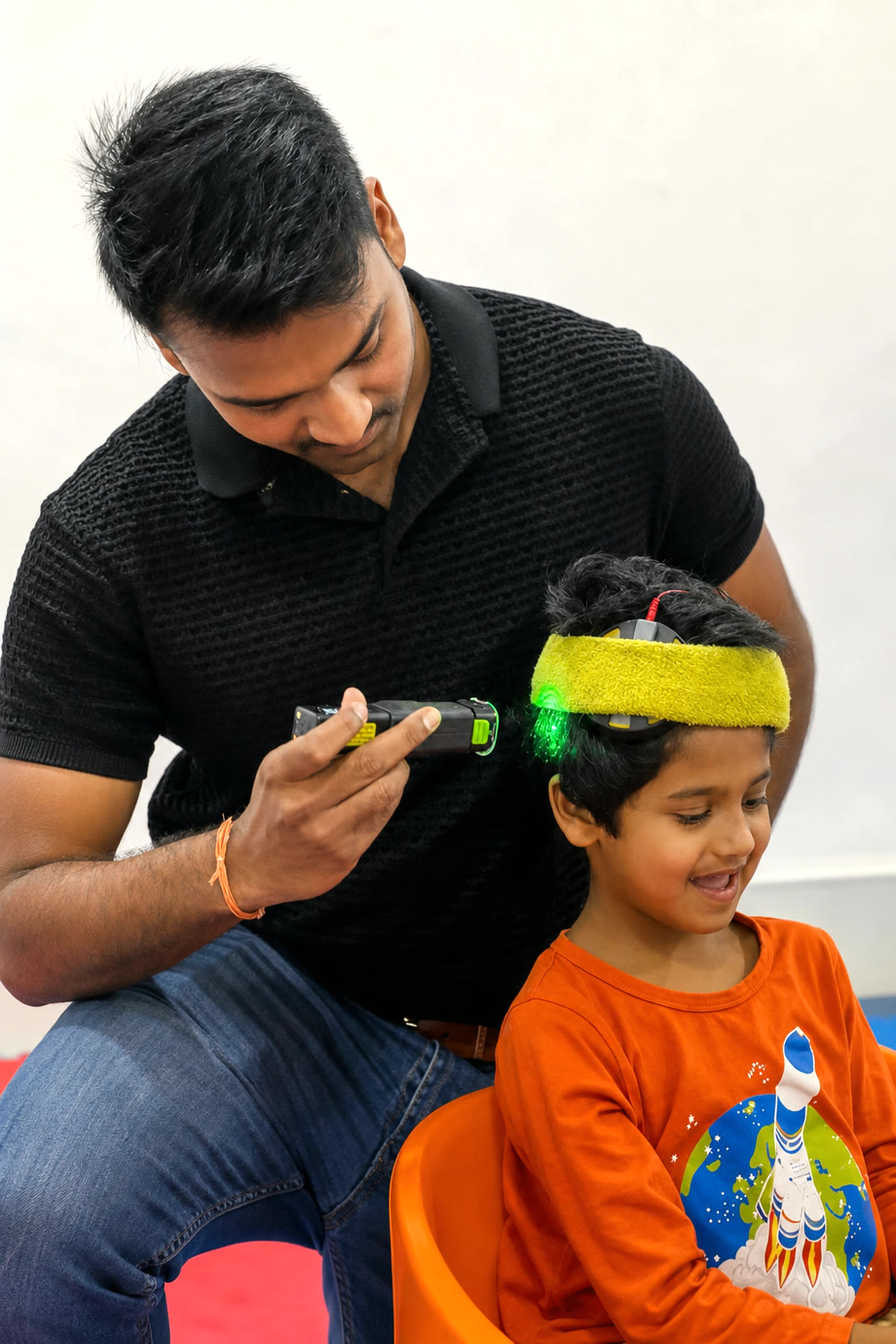 Dr. Aaditya providing supervised laser therapy support for a child at DARC